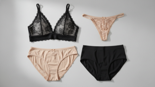 Everyday Lingerie Basics Folded bralette, bikini, thong, and seamless underwear on grey stone surface.